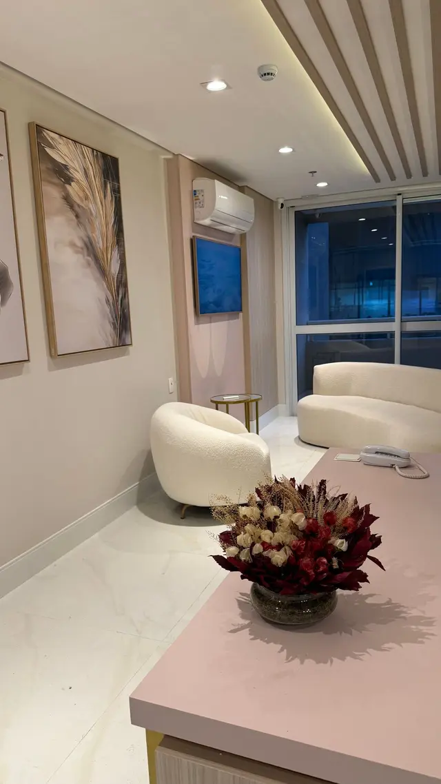 Sala de espera com sofá e poltrona claras