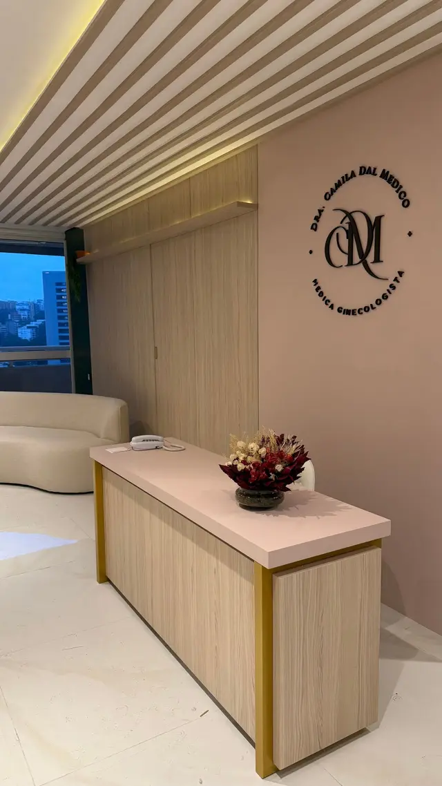 Recepção com balcão e logotipo da Dra. Camila Dal Medico